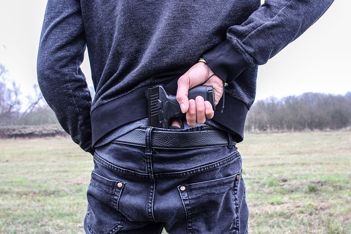 man getting a gun from his back